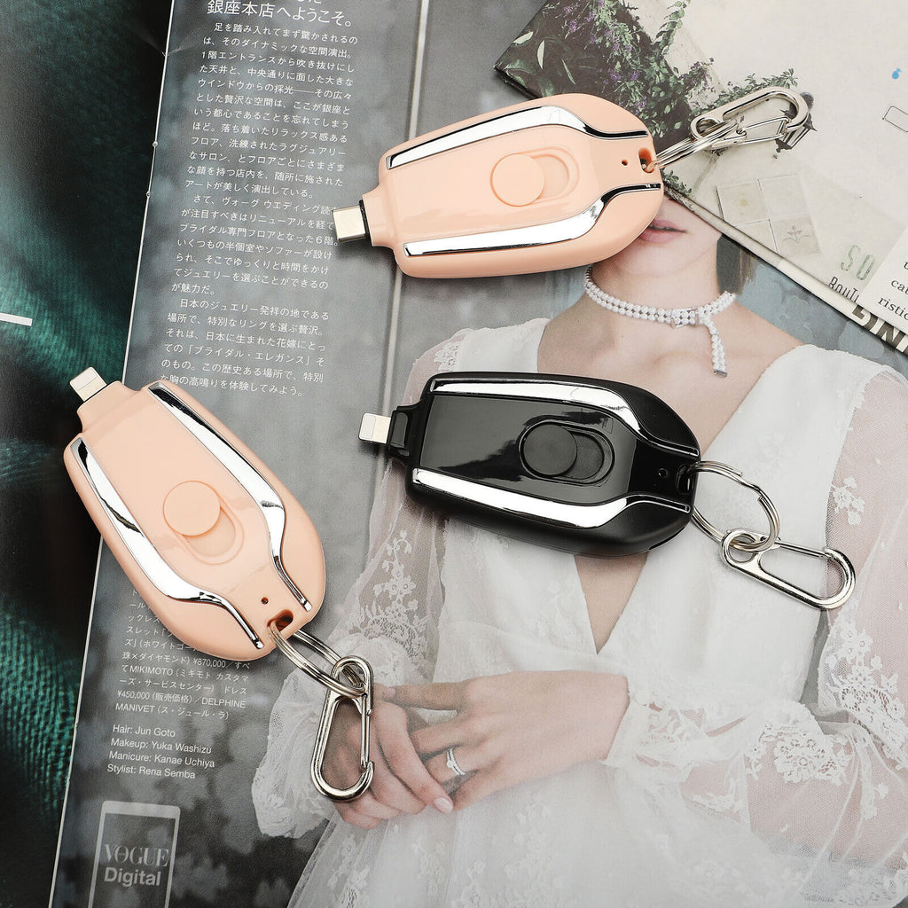 Two keychain devices with carabiners on a magazine background